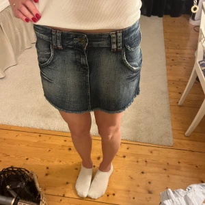 Jeanskjol med veck från stradivarius  - Så snygg jeanskjol från Stradivarius med slitna detaljer och fransig nederkant. Kjolen har två fickor framtill och en cool unik plisserad baksida. Midjemått: 38cm rakt över. Längd: 30 cm. Använd gärna köp nu 💕💕