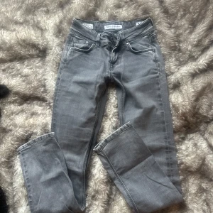 Grå jeansbyxor från Saturn - Snygga grå jeansbyxor från pepe jeans i en straight modell. Storlek W24 Inseam 32 och de har en straight passform