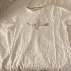 juicy t shirt - Säljer en vit t-shirt från Juicy Couture med glittrande logotyp på framsidan. T-shirten har korta ärmar och en rund halsringning. Jättesöt och aldrig använd bara tvättad.