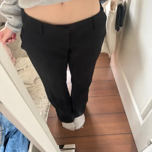 Svarta kostymbyxor - Snygga svarta kostymbyxor med en klassisk design. De har en rak passform och är perfekta för en stilren look. Byxorna har diskreta fickor och en smidig dragkedja framtill.