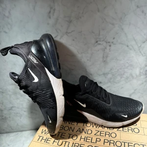 Svarta Nike Air Max  - Snygga svarta Nike Air Max sneakers med vit sula och röda detaljer under. Skorna har en luftig design med snörning och en synlig Air Max-enhet i hälen för extra komfort. Perfekta för både träning och vardag. Nypris: 2000kr