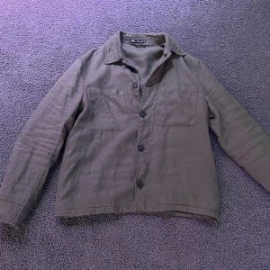 Grön overshirt  - Säljer en stilren grön overshirt från Zara. Den har långa ärmar och knappar framtill. 