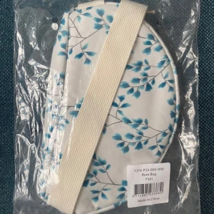 Vit och blå magväska med blommönster barn väska  - Snygg magväska med blommönster i blått på vit bakgrund. Tillverkad av återvunnet material och designad med miljövänliga principer. Perfekt för att bära dina nödvändigheter med stil.