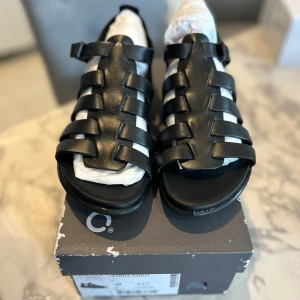  Svarta äkta skinn sandaler från ECCO - Helt nya och oanvända Svarta sandaler från ECCO. I äkta skinn med breda remmar och justerbart spänne vid ankeln. Platt sula och öppen tå, mycket bekväma, perfekt för varma dagar. Snyggt flätad design som passar till allt. 