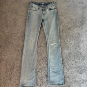 Ljusblå bootcut jeans lågmidjade  - Säljer ett par ljusblå jeans från Garcia med bootcut passform. Jeansen har klassisk femficksdesign, låg midja och en liten sliten detalj på ena benet. Tillverkade i mjukt bomullsmaterial med en snygg tvättad look. Säljer då dom inte kommer till användning längre😊 Storlek 26, längd 34. Passar storlek S 