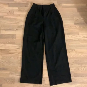 Svarta vida supersköna kostymbyxor - Säljer ett par svarta vida kostymbyxor med elastisk midja. Perfekta för en avslappnad stil och bekväma att bära. Passar bra till en enkel topp eller hoodie.