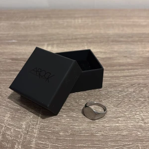 Silverfärgad ring från AROCK - Stilren silverfärgad klackring från AROCK med rundad, slät topp. Kommer med original ask. Passar både killar och tjejer som vill ha en clean look.