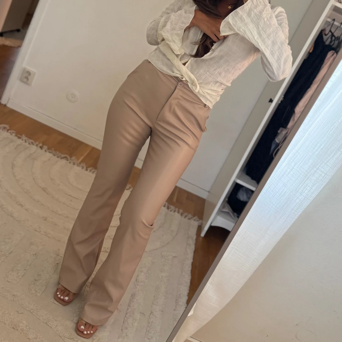 Beiga bootcut byxor i skinnimitation