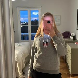 Grå hoodie med tryck och huva - Nypris 899kr