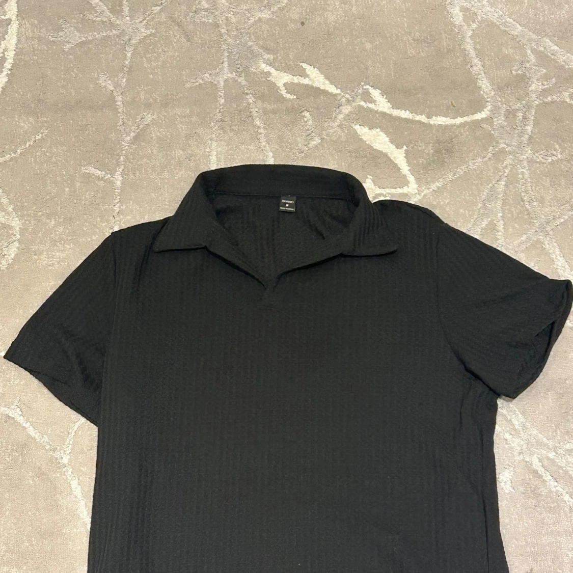 Svart pikétröja från Manfinity M