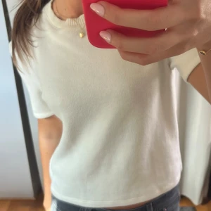 Vit stickad kortärmad topp - Enkel och stilren vit stickad topp med korta ärmar och rund halsringning. Mjuk och skön, perfekt till jeans eller kjol. Passformen är normal och toppen har en klassisk look som funkar året runt. Väldigt liten i passformen, är storlek L och jag brukar ha s/m. 
