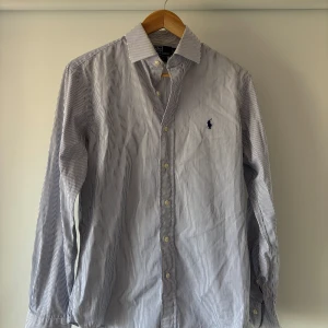 Ralph lauren skjorta - Riktigt fin blårandig ralph lauren skjorta i fint skick utan defekter. Storlek M skriv vid fundering