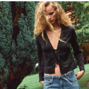 Svart knut blus/topp från Zara - Jättefin svart knut blus/topp från Zara med långa ärmar och djup v-ringning. Endast använd 1-5 gånger så är i väldigt bra skick. Bara att höra av sig för fler bilder🩷 originalpris 379 