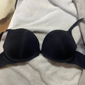  bh från Hunkemöller - Svart, slät och stilren bh från Hunkemöller i storlek 70C. Bhn har formade kupor och smala axelband, perfekt för en clean look under kläder. Materialet är mjukt och följsamt, vilket gör den bekväm hela dagen. Det är en bh med mycket push up och är hel vaderad🥰 har passat mig som har 75b också❤️
