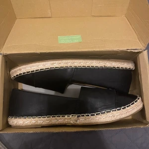 Svarta espadrillos från Boohoo - Snygga svarta espadrillos från Boohoo med flätad sula och rund tå. Skorna har en stilren design med en touch av krokodilmönster på tån. Perfekta för en avslappnad stil.