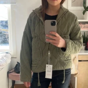 Grön jacka  - Säljer en skit snygg olivgrön quiltad jacka med dragkedja och stora fickor framtill. Passar perfekt till våren, hösten eller sena sommar kvällar, och är i ny skick. Har inte använt den så är det för jag säljer. Är väldigt lik den från Zara som inte finns kvar💚