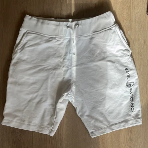 Vita shorts från Sail Racing - Snygga vita shorts från Sail Racing med broderad logga på benet. De har en bekväm passform med snörning i midjan och är perfekta för sommarens alla äventyr. Tillverkade i ett mjukt material som ger en skön känsla hela dagen.