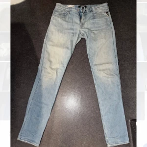 Ljusblå jeans från Replay - Snygga ljusblå jeans från Replay med klassisk femficksdesign och dragkedja. Perfekta för en avslappnad stil. Märkesdetaljer syns på fickan och baksidan. Storlek W33 L36