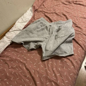 Grå shorts med snörning - Säljer ett par bekväma grå shorts med elastisk midja och snörning. Perfekta för en avslappnad stil.