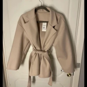 Beige kappa  - Snygg beige kappa från Missäy som jag köpte här på plick. Ganska ny och säljer pga inte min stil.