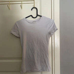 Vit t-shirt - Säljer en klassisk vit t-shirt med normal passform. Perfekt basplagg för alla tillfällen. Kortärmad och tillverkad i mjukt material för extra komfort.