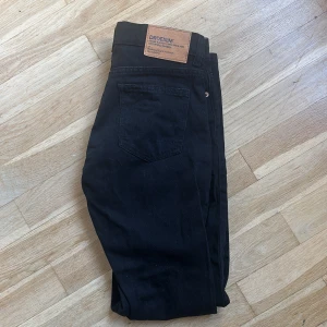 Svarta jeans från Dr. Denim - Snygga svarta jeans från Dr. Denim med klassisk femficksdesign och knappgylf. Perfekta för en stilren look. Tillverkade i ett bekvämt denimtyg som ger en skön passform. Aldrig använda då det var förstora. Köpt från Nelly.com för 799kr men säljer för 400kr⭐️
