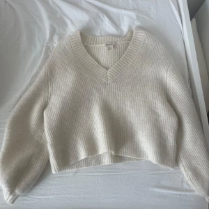 Vit mohair stickad tröja med v-ringning - Säljer en mysig vit stickad mohair tröja med v-rigning. Den är cropped med stora ärmar och ribbad för en stilren look. Passar perfekt till en kylig vårdag. Passar s-m, är lite oversize. Den är även kräm-vit så inte helt klar vit, helt oanvänd! Pris kan diskuteras.