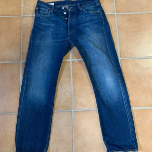 Levi's 501 jeans - Ett par snygga blåa jeans från levis 501 kollektion i bra skick. Förutom längs ner på byxorna då de har slitits lite men utöver de felfria!