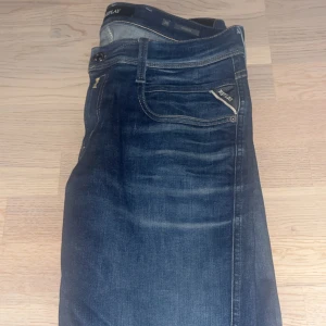 Mörkblå jeans från Replay - Riktig snygga mörkblå jeans från Replay med en klassisk femficksdesign. Jeansen har en normal passform och är tillverkade i ett slitstarkt denimtyg. Perfekta för en avslappnad stil. Strl 30-32 och är i toppskick inga defekter förekommer. Modellen är slim fit Anbass nypris 1799 mitt pris 600, kan gå ner i pris vid snabb affär!