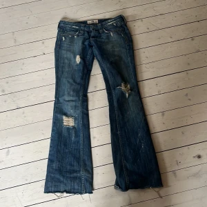 Blå bootcut jeans från Juicy Couture - Snygga blå bootcut jeans från Juicy Couture med slitna detaljer och en cool vintage-look. Dem är lågmidjade och as snygga bara lite försmå för mig🥰