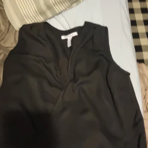 Svart ärmlös topp från Only Trend - Säljer en stilren svart ärmlös topp från Only Trend. Toppen har en v-ringad design och är perfekt för en minimalistisk look. Tillverkad i ett mjukt och bekvämt material.