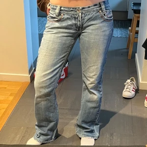 Ljusblå lågmidjade diesel jeans  - Säljer ett par ljusblå bootcut Diesel jeans med snygg tvätt och låg midja. Jeansen har normal passform och fem fickor. Perfekta för dig som gillar en tidlös stil med lite utsvängda ben. Dragkedjan är sönder men går att dra upp ändå så det varken syns eller märks. 