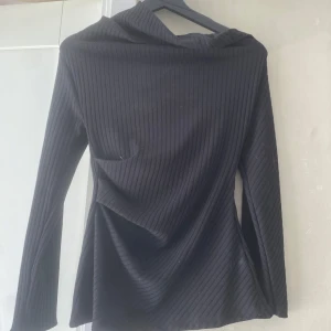 Svart långärmad tröja  - Svart långärmad tröja med huva och ribbad struktur. Helt oanvänd, köpte för cirka ett år sedan från Zaras hemsida, nypris 330kr!