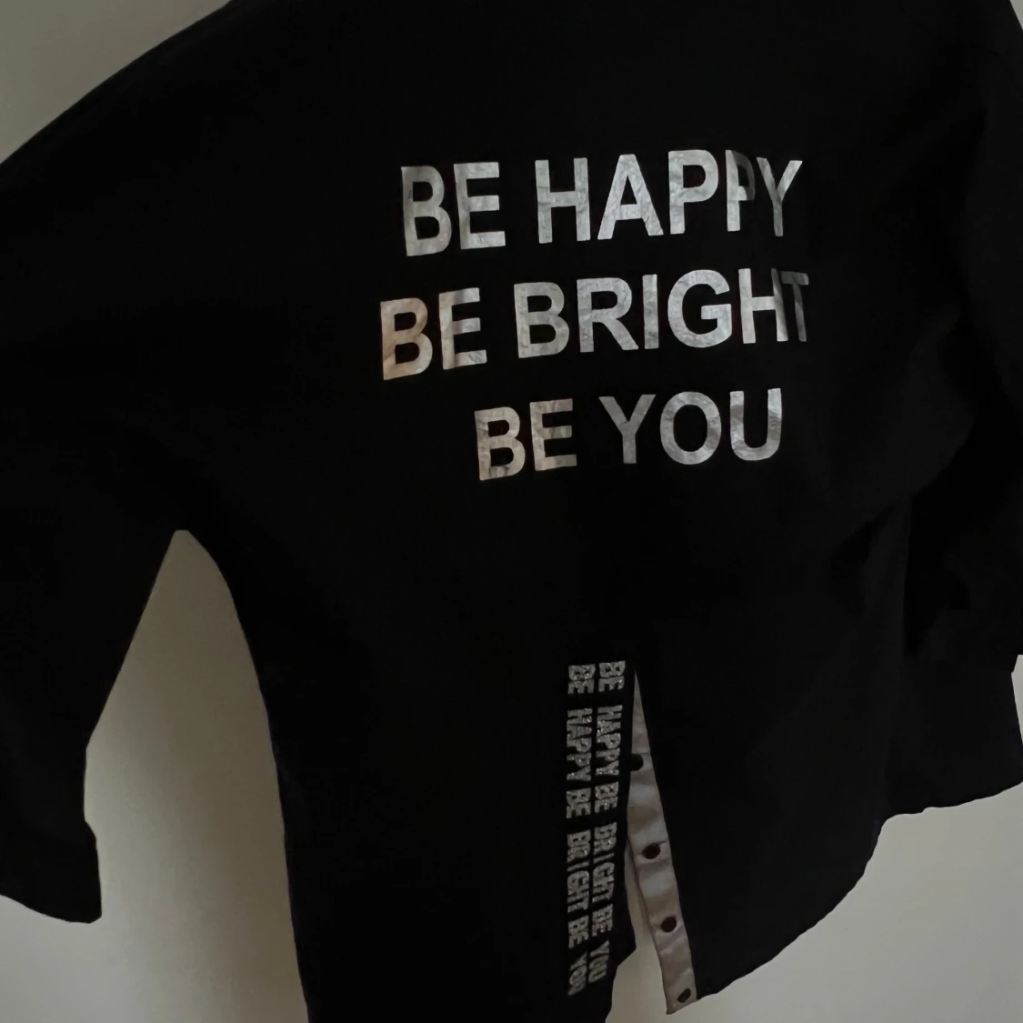 Svart skjortjacka med glittrig text från Saga - 1