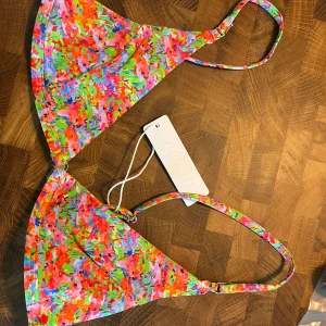 Färgglad blommig bikini från Bright - Super fin bikini från Bright men som tyvärr var för liten. (säljer även en likadan fast i blå). Helt ny bikini med prislapp som är för liten för mig och köpte den under en ”final sale” så går inte att skicka tillbaka. 🍉Bikinin är i storlek S men skulle mer säga att underdelen är som en XS och toppen som en S. Ser gärna att man köper hela settet