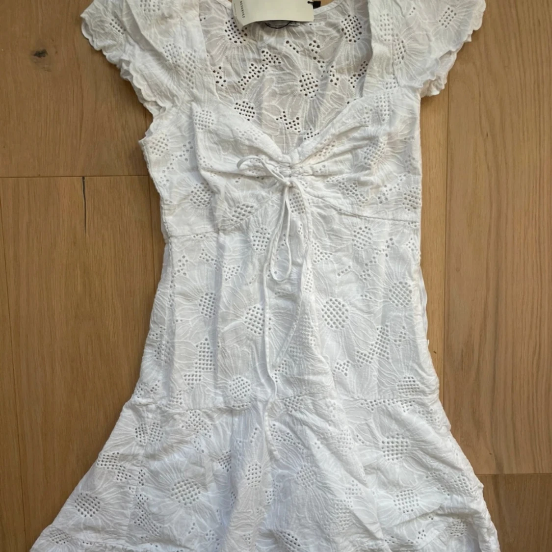 Vit kortklänning med broderade blommor och knyt - 1