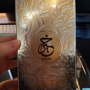 Khair Felicity parfym från Paris Corner - Lyxig parfym i en elegant förpackning med guld- och silverdetaljer samt ett orientaliskt mönster. Märkt med Khair och doften Felicity. Perfekt för dig som gillar exklusiva och unika dofter. Ny inplastad.