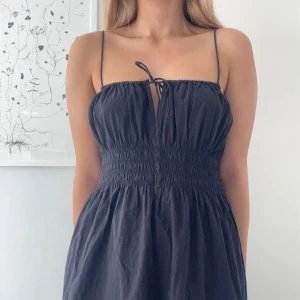 H&M Svart sommarklänning  - Svart klänning med smala axelband och knytning framtill från H&M💗Klänningen har rynkad midja och lätt utställd kjol.  Väldigt luftig och stretchig i materialet💗Perfekt för varma dagar! I storlek S