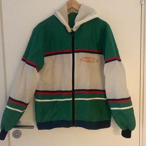 Fuji Film jacka - Jättecool vindjacka från Fuji Film! Vintage men knappt använd av mig. Fint skick förutom några fläckar och lös tråd enligt bild, men inget som märks egentligen.  