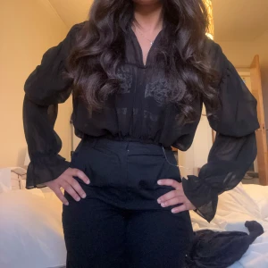 Svart blus från Nelly - Svart blus som passar till både fest och vardag från Nelly (NLY One). Storlek S. 🖤 Den är använd fåtal gånger och väldigt sparsamt! Säljer en annan i samma modell men vit färg & storlek M, man kan köpa båda för 150 kr! 🥰