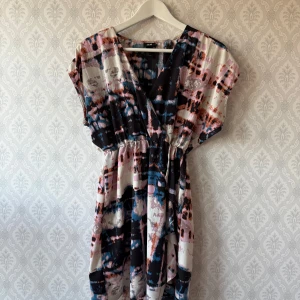 Mönstrad klänning från H&M - Sommarklänning i härliga färger H&M. Resår i midjan för en snygg siluett. Rökfritt hem. 