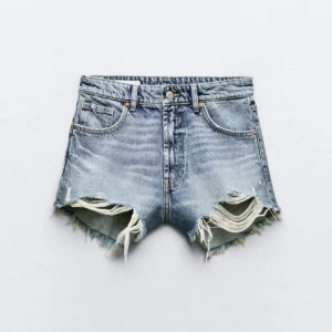 Blå högmidjade jeansshorts med slitningar - Snygga blå jeansshorts med hög midja och råa, slitna kanter. Shortsen har klassisk femficksdesign och coola slitningar framtill för en avslappnad vibe. Perfekta för varma dagar och en trendig streetstyle-look.