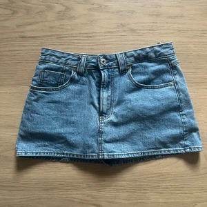 Jeanskjol från Stradivarius - Säljer denna super fina jeanskjol från strandivarius💕 Den är lågmidjad och har som shorts under ( syns ej när man har på sig den) endast använt en gång😊 nypris:400kr