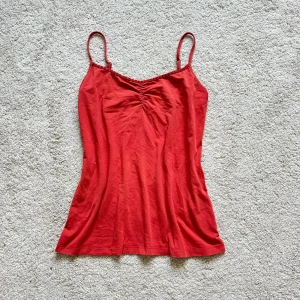 Oranget linne med pärlor  - Snyggt oranget linne som tyvärr är för stort för mig! Finns ingen lapp på, skulle gissa storlek M.  Fina pärldetaljer på toppen och inga skavanker. Går nedanför naveln!