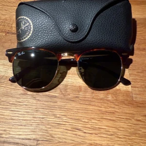 Ray-Ban Clubmaster solglasögon brun/guld - Säljer ett par Ray-Ban Clubmaster RB3016 med klassisk brunsköldpaddsmönstrad båge och guldiga detaljer. Glasen är mörka och modellen är ikonisk med retrovibbar. Kommer med original fodral.
