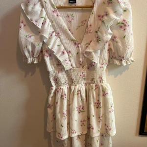 Söt sommarklänning - Jättefin sommarklänning med blommor från ginatricot i storlek XS. Den här lite puffiga ärmar och resår i midjan för att markera. Endast använd en gång, så jättefint skick. Nypris 399kr (köpt förra våren). 🌸