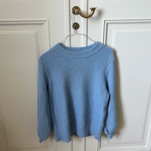 Ljusblå stickad tröja Filippa K XL - Superfin ljusblå stickad tröja från Filippa K i storlek XL. Tröjan har en klassisk rund halsringning, ribbade muddar och är långärmad. Perfekt för lager-på-lager och chill vibes. Materialet är mjukt och ger en avslappnad men stilren look.