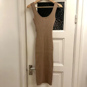 Ribbad midiklänning  - Beige ribbad klänning i midilängd från Missguided i storlek S. Tight passform med stretch. Använd 1-3ggr.