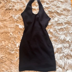 Svart halterneck kortklänning - Snygg svart kortklänning med halterneck och djup urringning