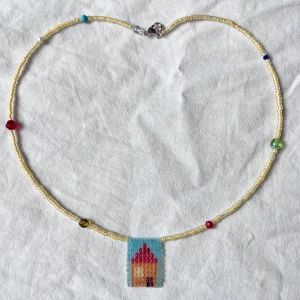 Handpärlat halsband med unikt hänge - Väldigt gulligt, färgglatt halsband med handpärlat hänge med motiv av ett hus, pärlat med tekniken ”square beading”. Handgjord av mig!✨